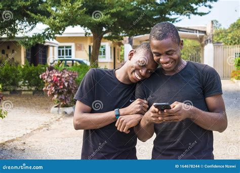 Coppia Gay Che Ride Insieme Mentre Usa Il Telefono Due Giovani Neri Che Camminano E Si Tengono