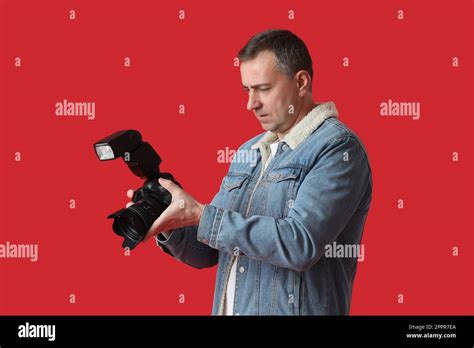 Mature Photographer With Professional Camera On Red Background Stock