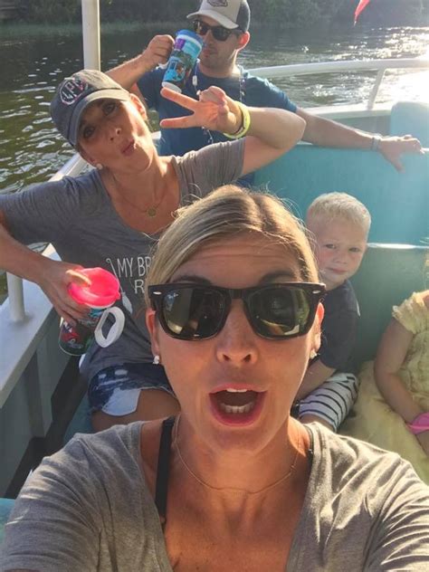 A Group Of People Riding On Top Of A Boat In The Water With One Person