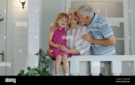 Les Grands Parents Heureux Se Couple Avec La Petite Fille Souriant Dans