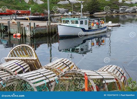 Trampas De Madera De La Langosta Y Un Barco De Pesca En La Ensenada De