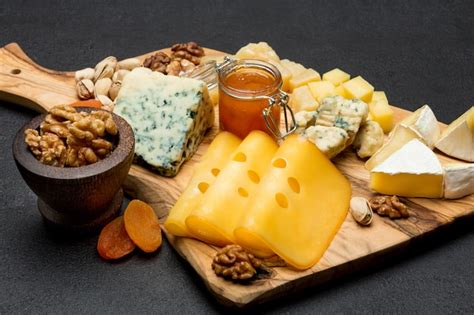 Premium Photo Brie Camembert Roquefort And Cheddar On Wooden Board