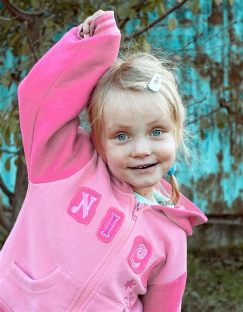 Premium Photo Portrait Of Cute Girl Smiling While Standing Outdoors