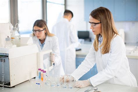 Foto De Female Scientists In A White Lab Coat Putting Vial With A