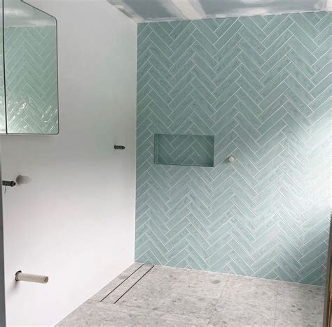 An Empty Bathroom With Blue And White Tiles On The Wall Shower Stall