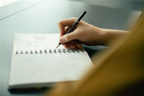 Person Drawing on a Sketchbook · Free Stock Photo