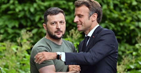 Zelensky Looks Grim Faced As Macron Leans In For An Awkward Hug In Kyiv