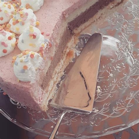 A Piece Of Cake On A Glass Plate With A Serving Utensil Next To It