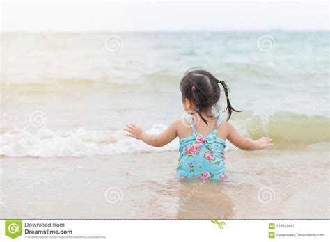 Menina Que Senta Se E Que Joga Na Praia Areia Imagem De Stock