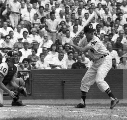 An Old Black And White Photo Of A Baseball Player Holding A Bat In