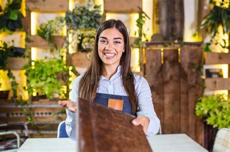 Happy Beautiful Smiling Waitress Wearing Apron Giving A Folder Menu In