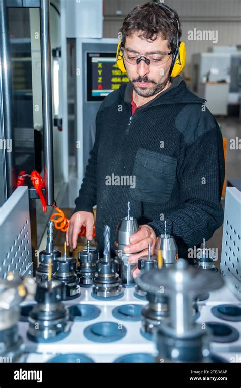 Photo Verticale D Un Ouvrier Choisissant La Taille D Un Tour Pour