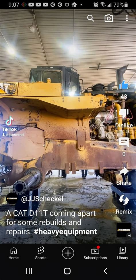 A Yellow Bulldozer Sitting Inside Of A Garage