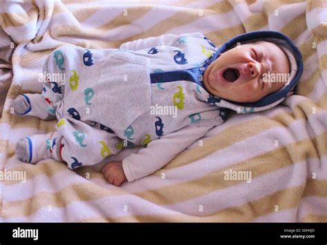 Newborn sleepy baby boy yawning Stock Photo - Alamy