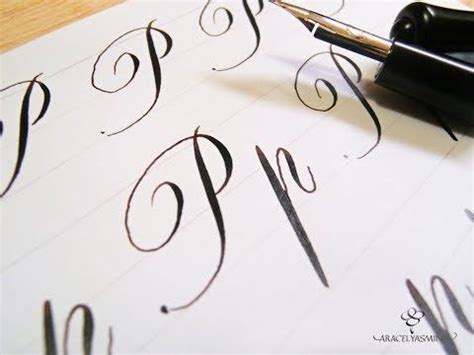 An Ink Pen Writing On Paper With The Letter P In Cursive