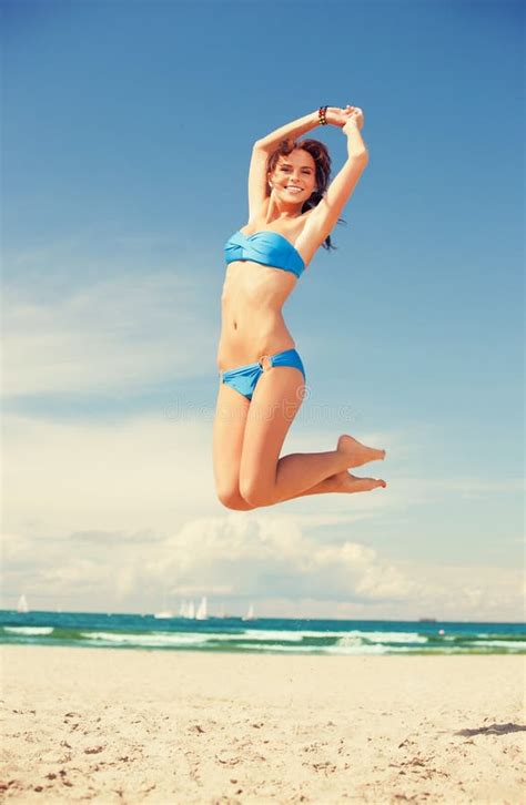 Woman With Bikini Jumping Happily On The Beach Portrait Stock Image