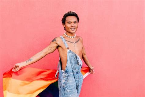 Hombre Gay Sonriente Sosteniendo La Bandera Del Arco Iris Foto Premium