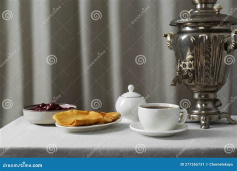 Vintage Samovar Cup Of Hot Drink And Snacks Served On Table Indoors