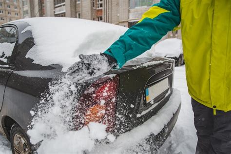 Premium Photo Man Cleaning His Car After Snow Storm