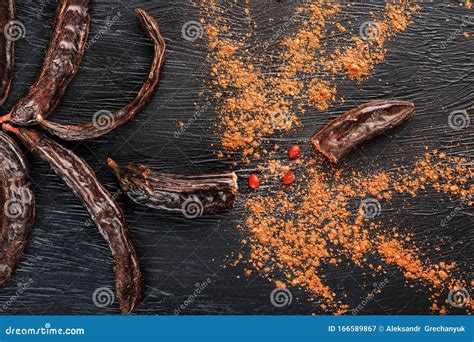 Frutos De Algarrobo Sobre Un Fondo Negro Texturado En Forma De Flor Que