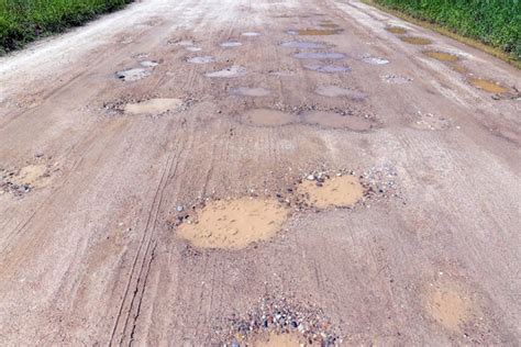 Uma estrada de terra muitos furos de água Foto Premium