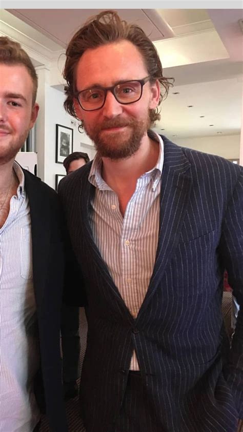 Two Men Standing Next To Each Other Wearing Glasses