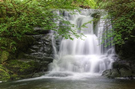 Stunning Waterfall Flowing Over Rocks Through Lush Green Forest