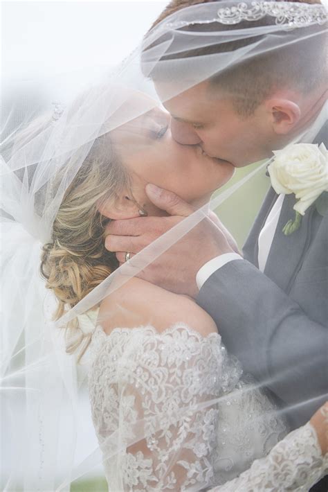 A Beautiful Moment Bride And Groom Kissing Under The Veil