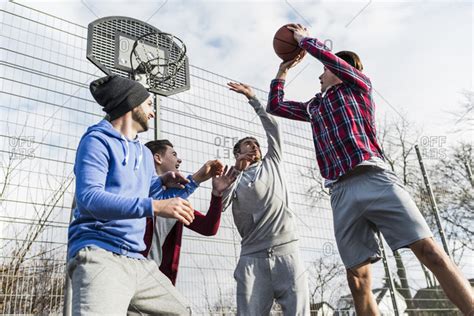 Young men playing a pick up game of basketball stock photo - OFFSET