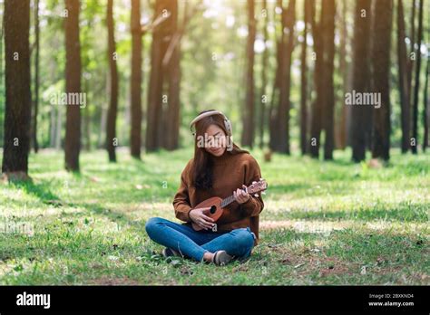 A Beautiful Asian Woman Enjoy Listening To Music With Headphone While