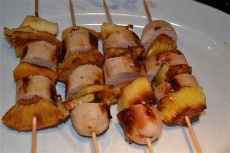 Several Skewers Of Food On A White Plate