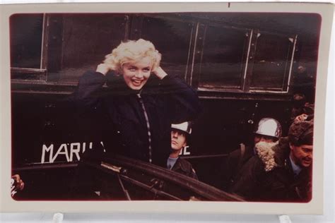 An Old Photo Of Marilyn Monroe Standing In Front Of A Police Car With