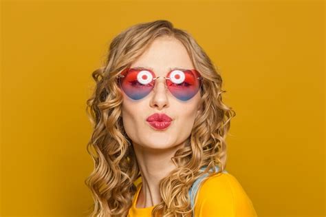 Premium Photo Young Happy Woman In Sunglasses Blowing Kiss On Yellow