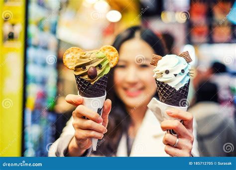 Young Female Model Eating Ice Cream Cone On Hong Kong Street Stock