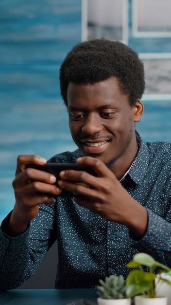 Homem afro americano jogando videogame no telefone Foto Grátis