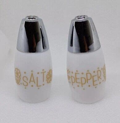 Two Salt And Pepper Shakers Sitting Next To Each Other