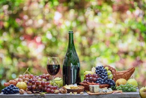 Garrafa De Vinho E Diferentes Queijos Sobre Mesa De Madeira E Fundo De