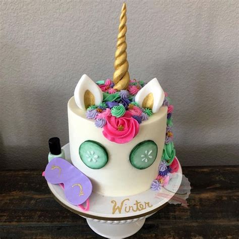 A White Cake Decorated With An Unicorn S Head And Flowers