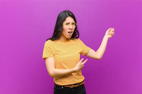 Jovens bonitas mulher latina sentindo se chocado e surpreso apontando para copiar o espaço ao