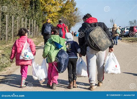 Refugees Walking Carrying Heavy Bags On The Croatia Serbia Border