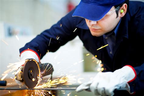 Worker grinding a metal plate - Metals USA