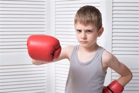 Niño enojado en guantes de boxeo rojos Foto Premium