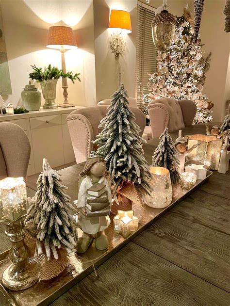 A Table Topped With Christmas Trees And Candles