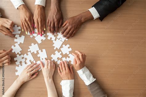 Hands Of Multi Ethnic Team Assembling Jigsaw Puzzle Multiracial Group