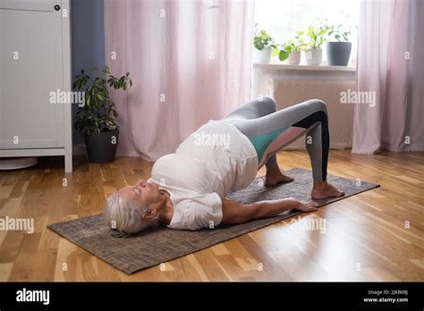 Senior Athletic Yoga Woman Doing Ardha Chakrasana Wheel On Yoga Mat At