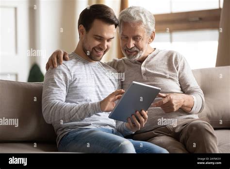 Grownup Son Teaching Elderly Mature Father Using Applications On Tablet Stock Photo Alamy