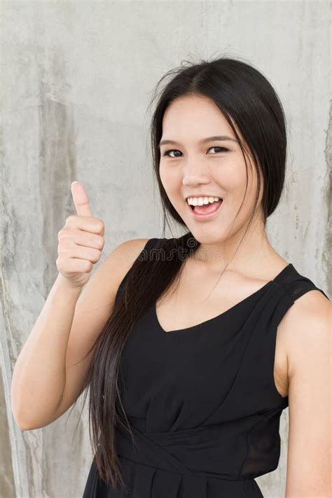 Mujer Sonriente Que Muestra El Pulgar Para Arriba Foto De Archivo