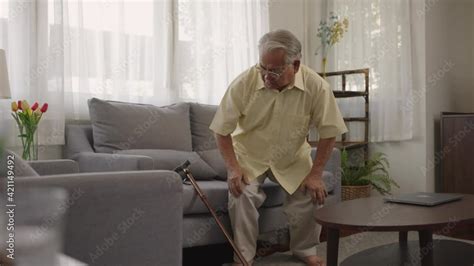 Asian Old Man Hold Wooden Walking Stick Sit On Couch In Living Room