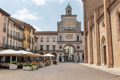 An Old Town Square With Tables And Umbrellas