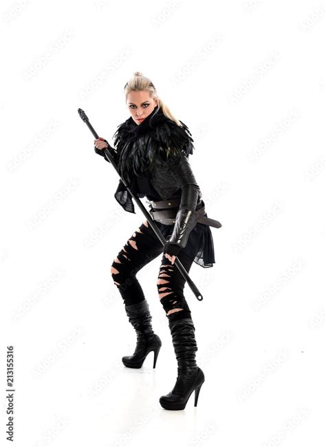 Full Length Portrait Of Blonde Girl Wearing Black Gothic Outfit Holding A Staff Standing Pose